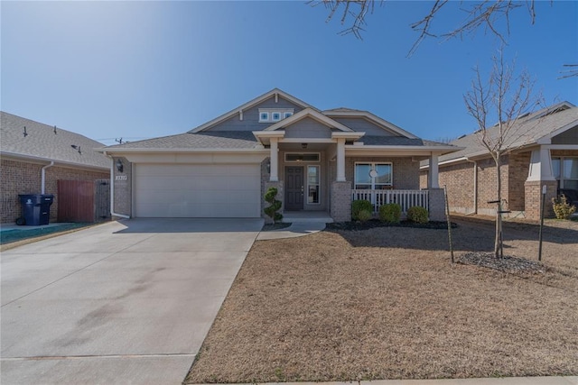 craftsman-style house with a garage, brick siding, covered porch, and concrete driveway