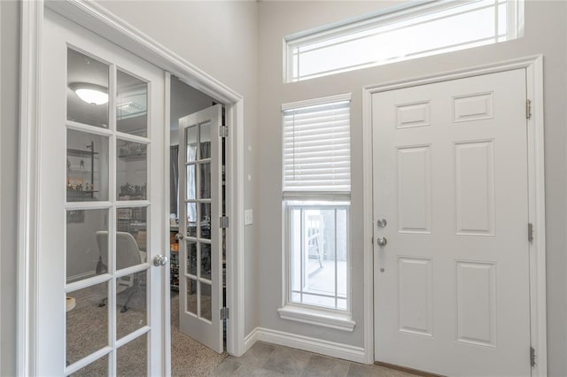 foyer entrance featuring french doors and baseboards