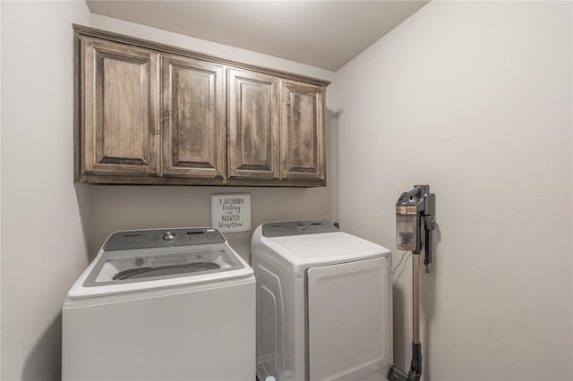 laundry area featuring washing machine and clothes dryer and cabinet space