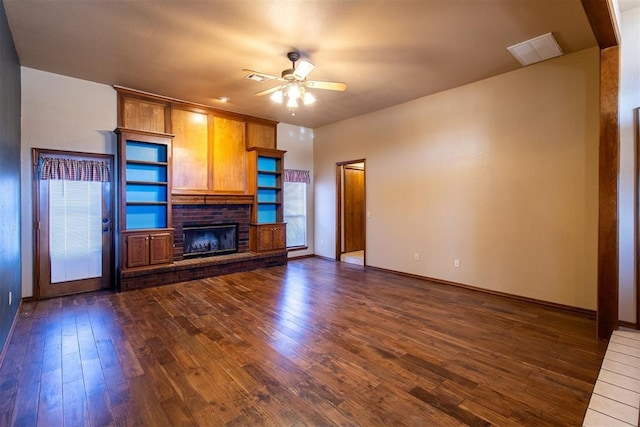 unfurnished living room featuring dark wood finished floors, a fireplace, visible vents, and ceiling fan