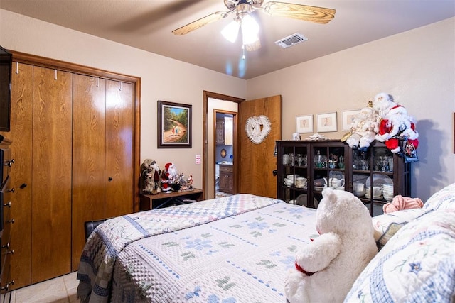 bedroom with light tile patterned floors, visible vents, a closet, and ceiling fan