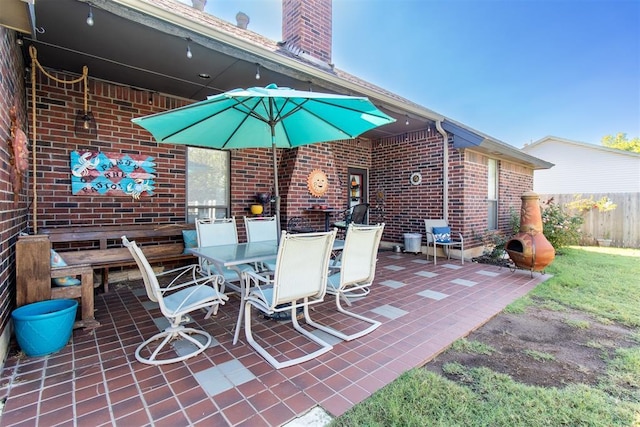 view of patio with outdoor dining space and fence