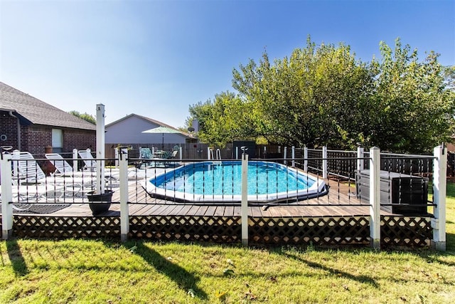 view of swimming pool with a fenced in pool, a wooden deck, a yard, and fence