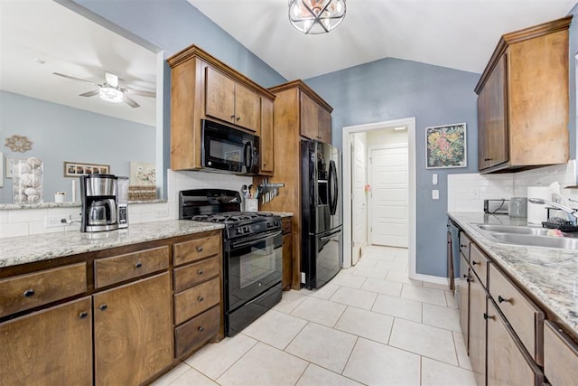 kitchen featuring ceiling fan, lofted ceiling, light tile patterned floors, black appliances, and a sink