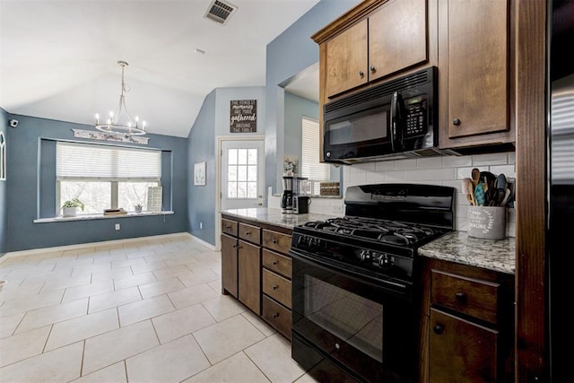 kitchen with light stone counters, visible vents, lofted ceiling, black appliances, and tasteful backsplash