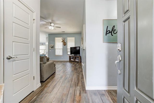 entrance foyer featuring baseboards, a ceiling fan, and dark wood-type flooring