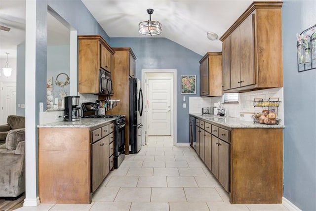 kitchen with backsplash, vaulted ceiling, light stone counters, and black appliances