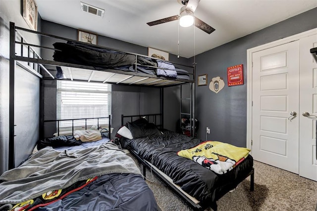 carpeted bedroom featuring ceiling fan and visible vents