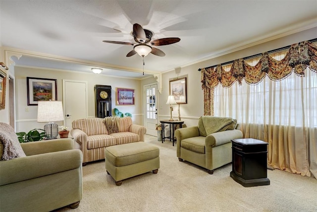 living room with ceiling fan, ornamental molding, and light carpet