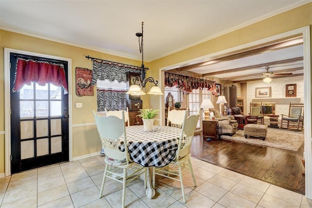 dining room with beam ceiling, a ceiling fan, crown molding, light tile patterned floors, and baseboards