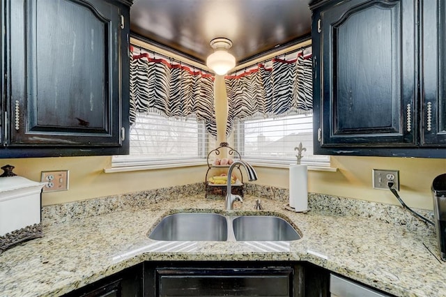 kitchen featuring a sink and light stone countertops