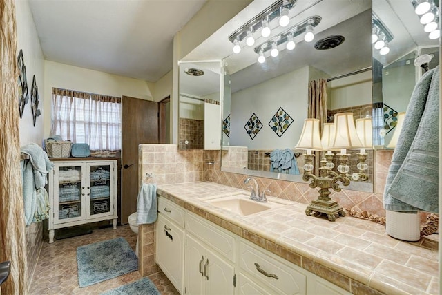 full bathroom featuring curtained shower, backsplash, vanity, and toilet