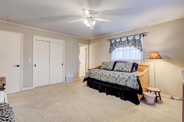 carpeted bedroom with a ceiling fan, baseboards, ornamental molding, a closet, and a textured ceiling