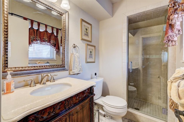 bathroom featuring vanity, toilet, and a shower stall