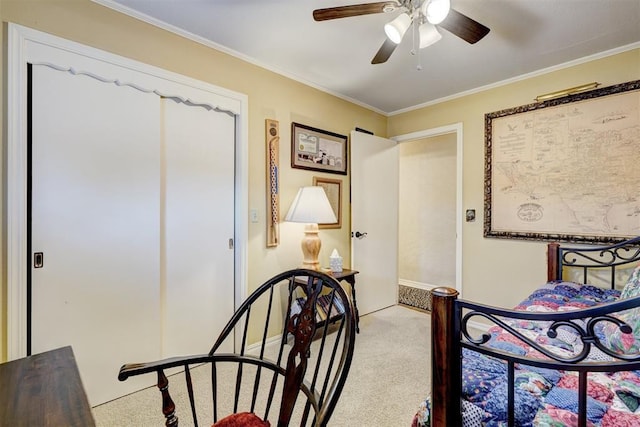 carpeted bedroom featuring ceiling fan and crown molding