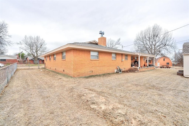 back of house featuring a patio, fence, crawl space, brick siding, and a chimney