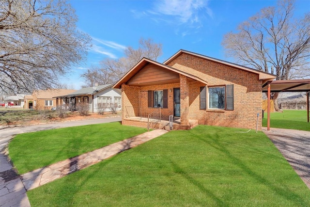 view of front of property with a carport, brick siding, and a front lawn