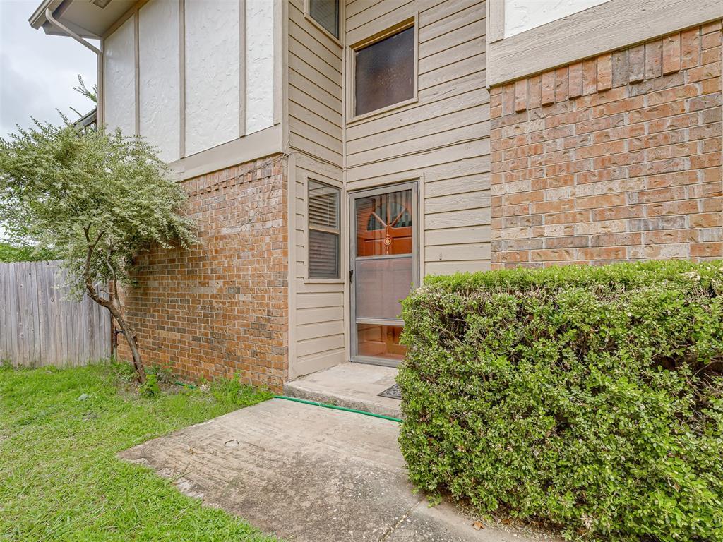 entrance to property featuring brick siding and fence