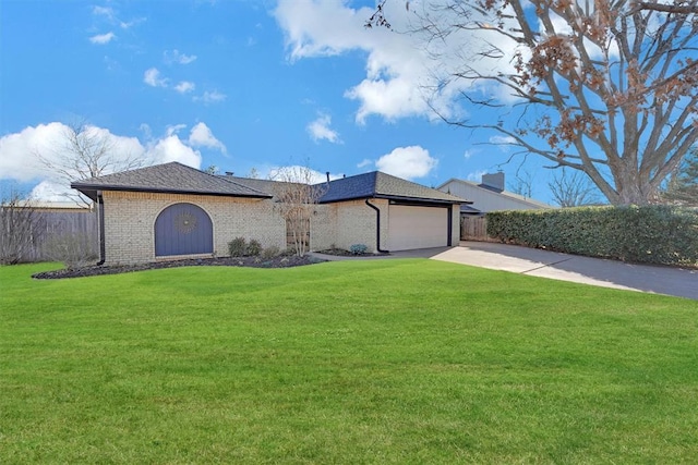 ranch-style home featuring a front lawn, fence, concrete driveway, an attached garage, and brick siding