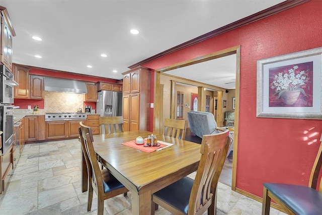 dining area with stone tile flooring, recessed lighting, and crown molding