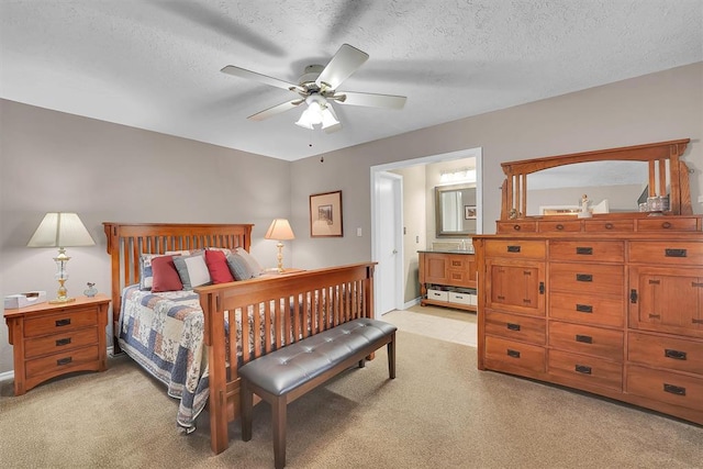 bedroom with light carpet, a textured ceiling, and ensuite bathroom