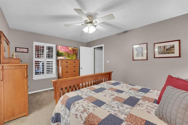 bedroom featuring baseboards, a textured ceiling, carpet, and a ceiling fan