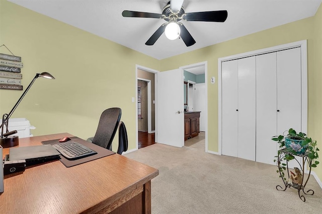 carpeted office space with a ceiling fan