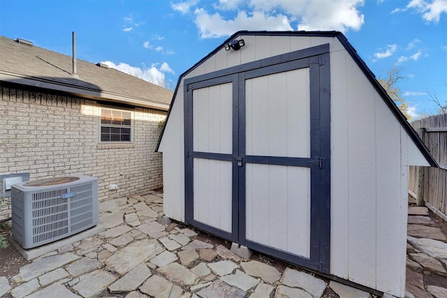 view of shed with central AC unit and fence