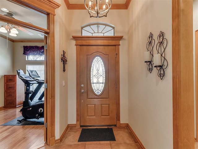 foyer featuring an inviting chandelier, baseboards, and ornamental molding