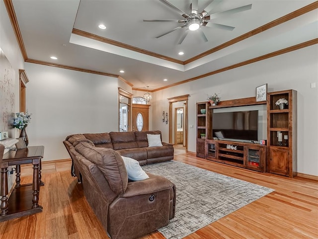 living room featuring recessed lighting, a tray ceiling, and wood finished floors