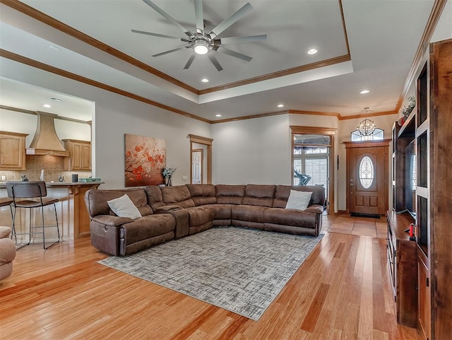 living room with ceiling fan, a raised ceiling, light wood-style flooring, and recessed lighting