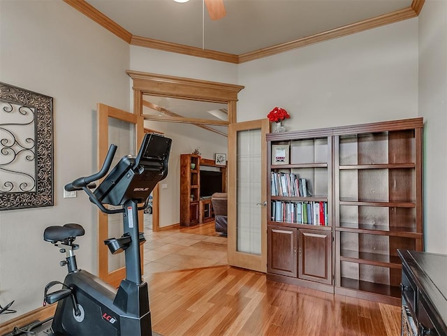 exercise room featuring crown molding, light wood-style flooring, and ceiling fan