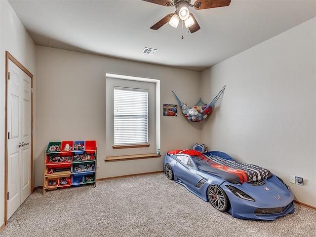 carpeted bedroom featuring baseboards, visible vents, and ceiling fan