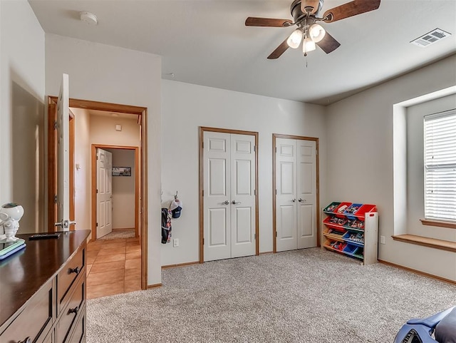 recreation room featuring visible vents, light colored carpet, baseboards, and a ceiling fan