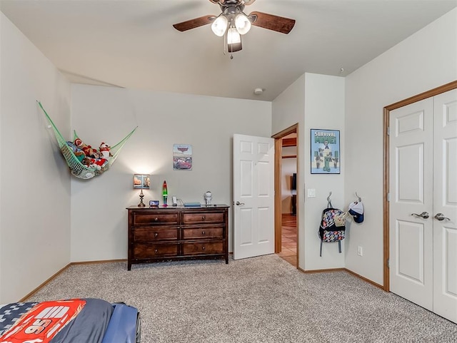 bedroom featuring a ceiling fan, carpet, baseboards, and a closet