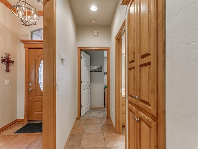 entryway with light tile patterned floors, visible vents, baseboards, and a notable chandelier