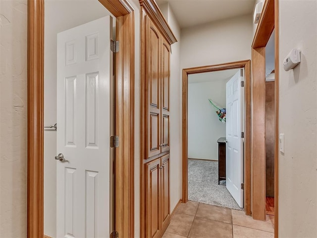 corridor featuring light tile patterned floors and light carpet