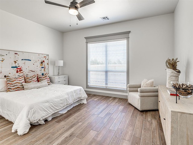 bedroom featuring wood finished floors, visible vents, and ceiling fan