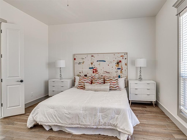 bedroom with baseboards and wood finished floors