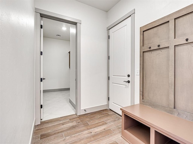 mudroom featuring baseboards and wood finish floors