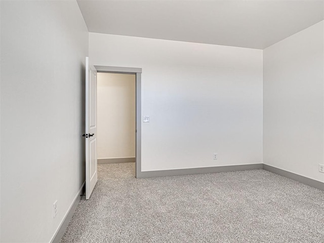 spare room with baseboards and carpet flooring