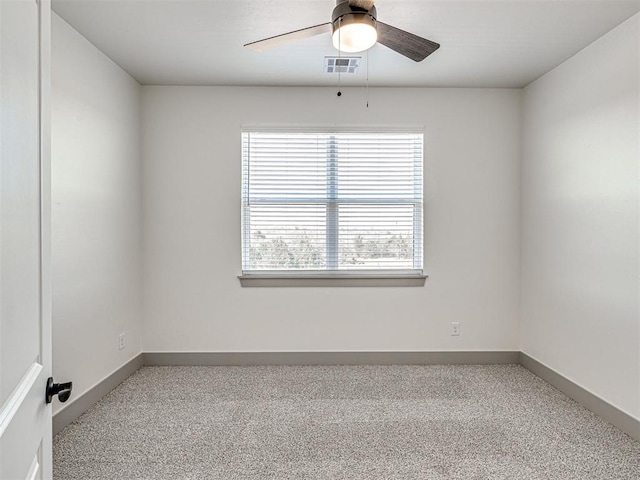 carpeted empty room with visible vents, baseboards, and ceiling fan