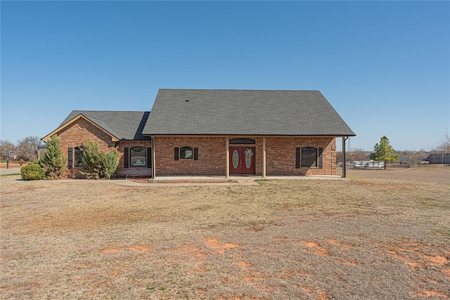 view of front of house featuring brick siding and a shingled roof