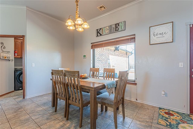 dining room featuring visible vents, baseboards, ornamental molding, washer / dryer, and a notable chandelier