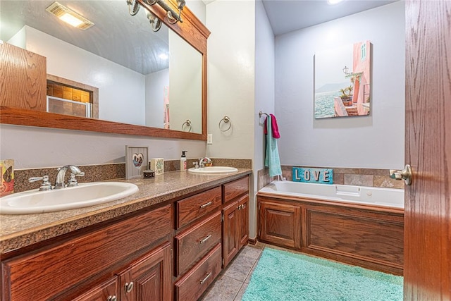 bathroom featuring a sink, a garden tub, double vanity, and tile patterned floors