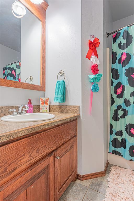 bathroom featuring tile patterned floors, vanity, and baseboards