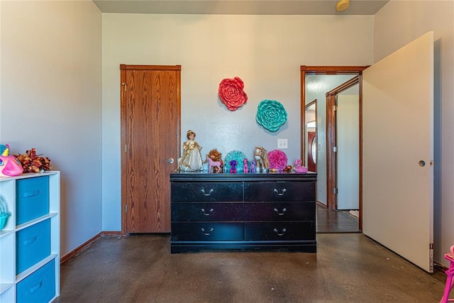 bedroom featuring baseboards and concrete floors