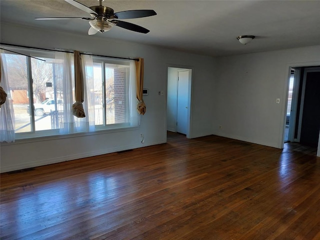 unfurnished room featuring baseboards, wood finished floors, and a ceiling fan