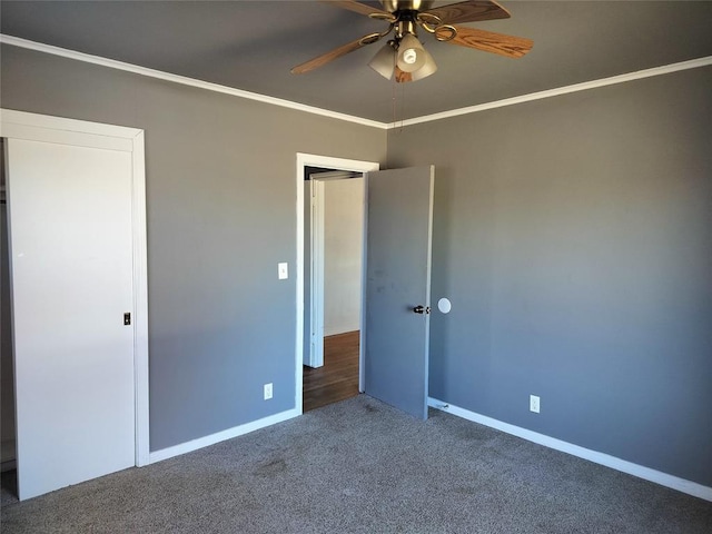 unfurnished bedroom featuring carpet flooring, baseboards, ceiling fan, and crown molding