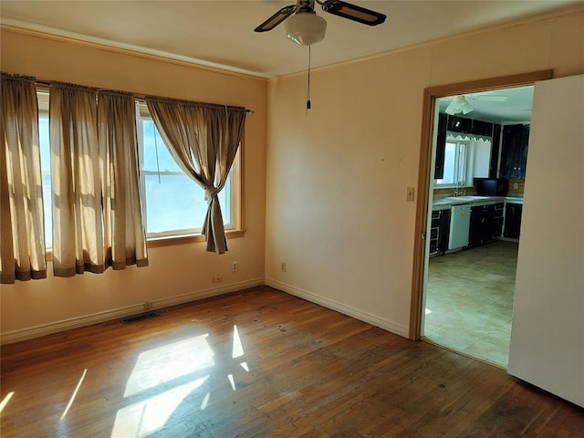 spare room with visible vents, baseboards, hardwood / wood-style floors, and ornamental molding